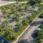 Aerial view of a commercial property entrance in South Florida with neatly trimmed trees and hedges.